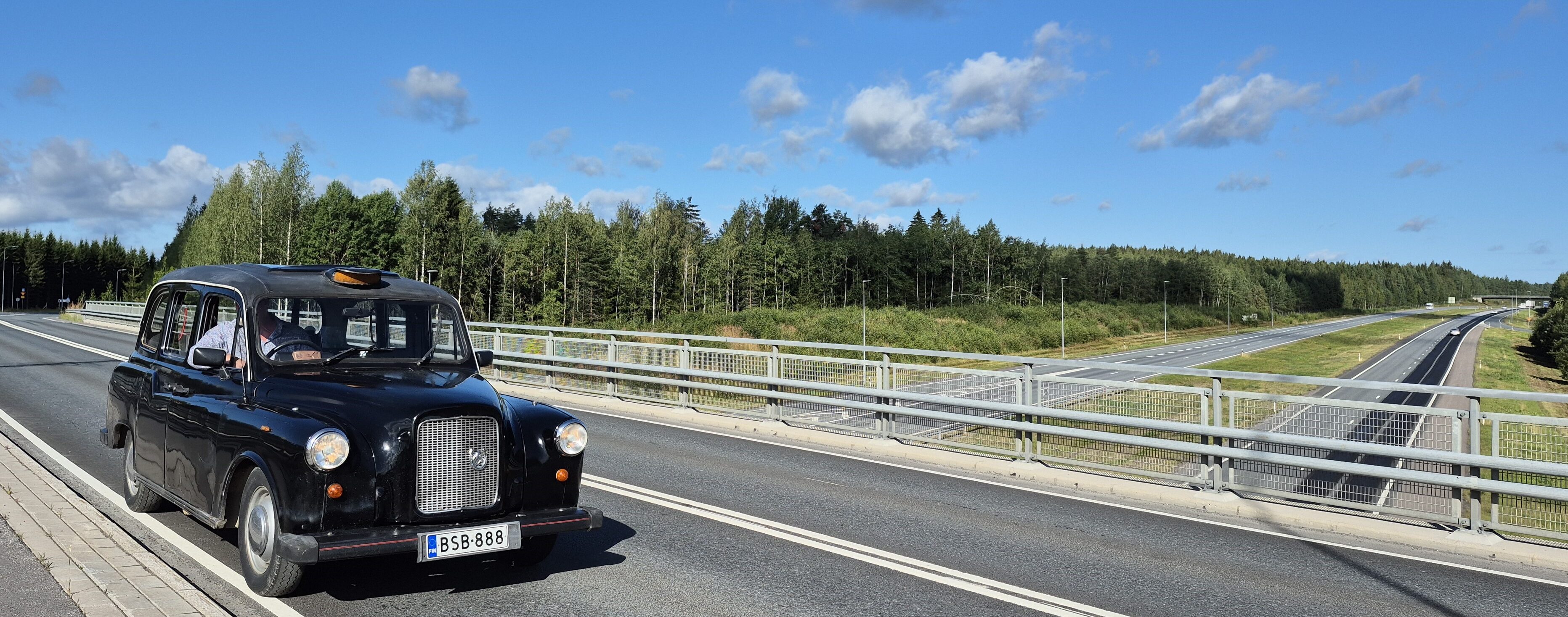 Musta auto moottoritien sillalla.
