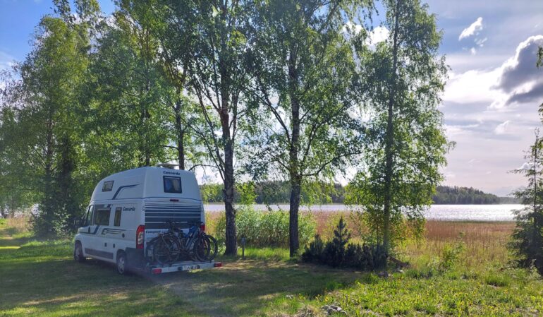 Matkailuauto järven rannassa.