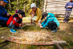 Lapset tekevät luonnonmateriaaleista käsitöitä Laurinmäen torpparimuseolla.