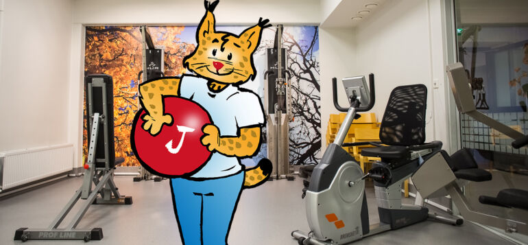 Janakkalan ilves-maskotti jumppapallon kanssa kuntosalilla.