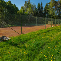 Tenniskenttä aurinkoisena kesäpäivänä.