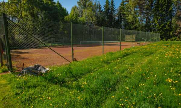 Tenniskenttä aurinkoisena kesäpäivänä.