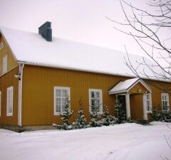 Keltainen Tarinmaan Vpk-talo lumivaipan keskellä.
