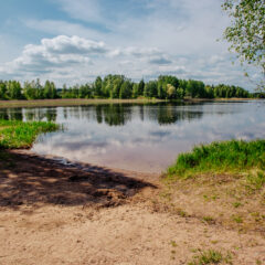 Aurinkoisena päivänä kuvattu järven hiekkaranta Rantalahdessa.