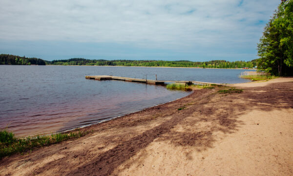 Suruttoman hiekkaranta Alasjärven rannalla aurinkoisena kesäpäivänä.