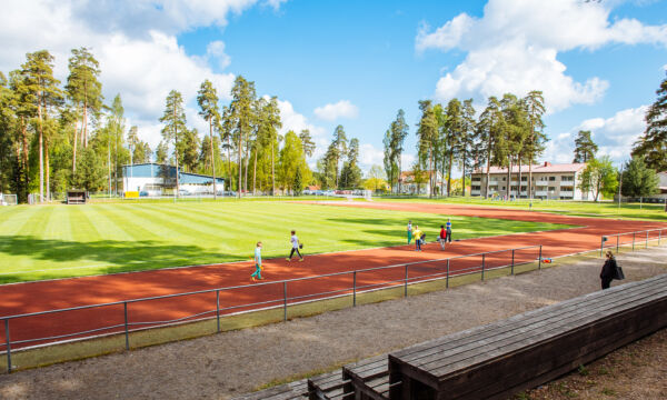 Urheilukenttä ja katsomon puupenkit.