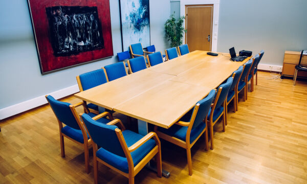 Kokoustila Hamppulan kokouspöytä ja siniset tuolit sen ympärillä.