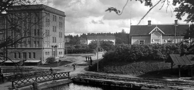 Joen rannassa ohoaa mahtava punatiilinen rakennus.