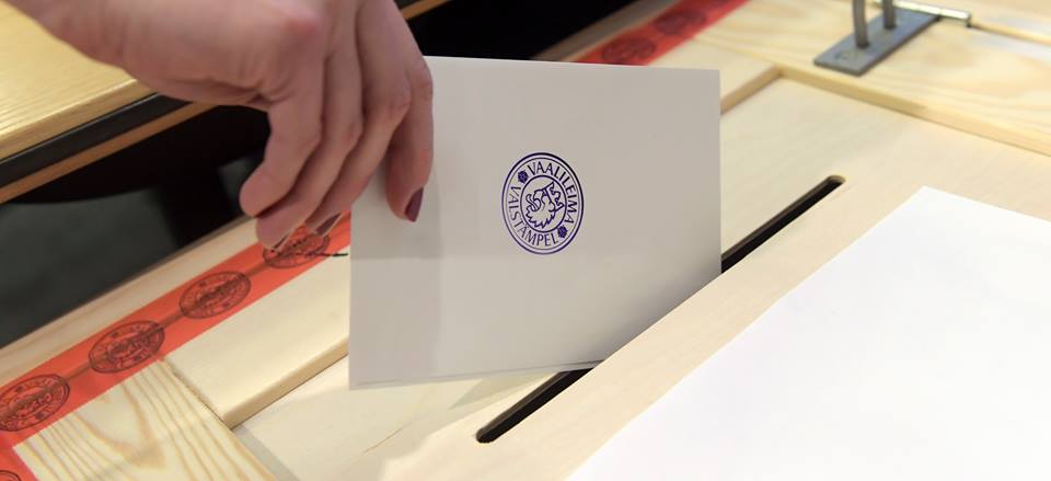 Henkilö tiputtaa äänestyslipukkeen äänestysuurnaan.