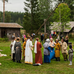 Vanhoihin vaatteisiin pukeutuneita museolla.