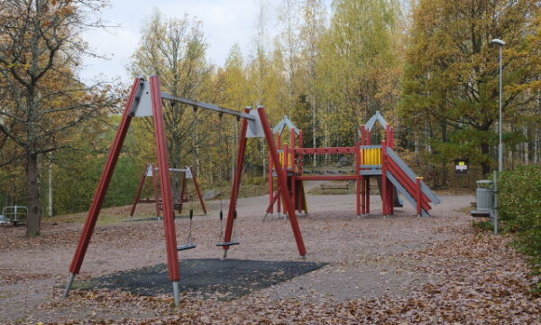 Keinut ja kiipeilyteline liukumäellä Tammirannan leikkipaikalla.