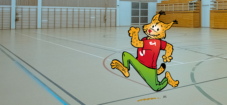 Janakkalan piirretty maskotti-ilves juoksee Turengin liikuntahallin salissa.