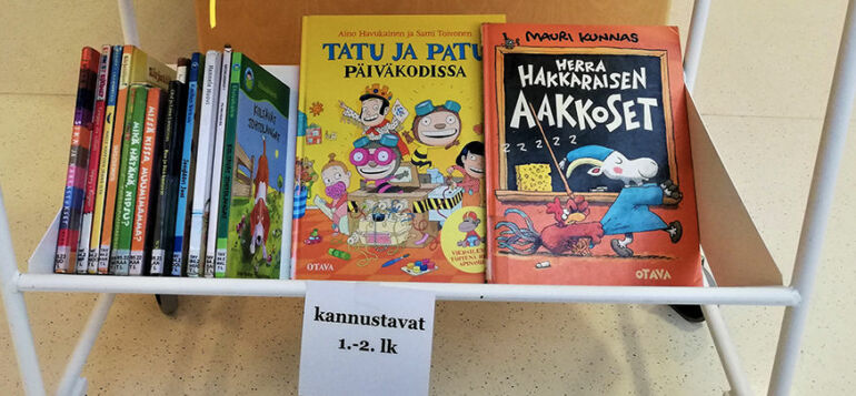 1. ja 2. luokan kannustava lukudiplomin kirjoja kirjakärryssä.