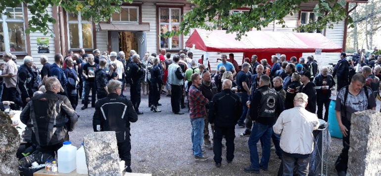 Paljon ihmisiä kerääntyneenä kesäpäivänä Mallinkaisten kyläkoulle motoristitorstaina.