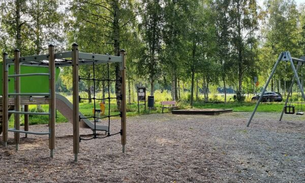 Mäntyniemen leikkipaikan kiipeilyliuku sekä keinut ja hiekkalaatikko.