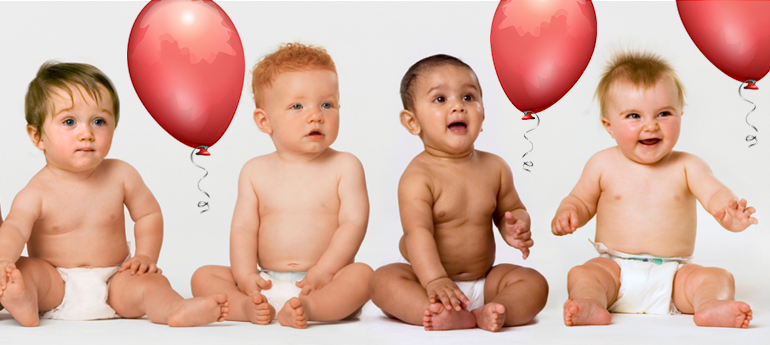 Neljä iloista vauvaa istumassa vaippasiltaan sekä ilmapalloja.