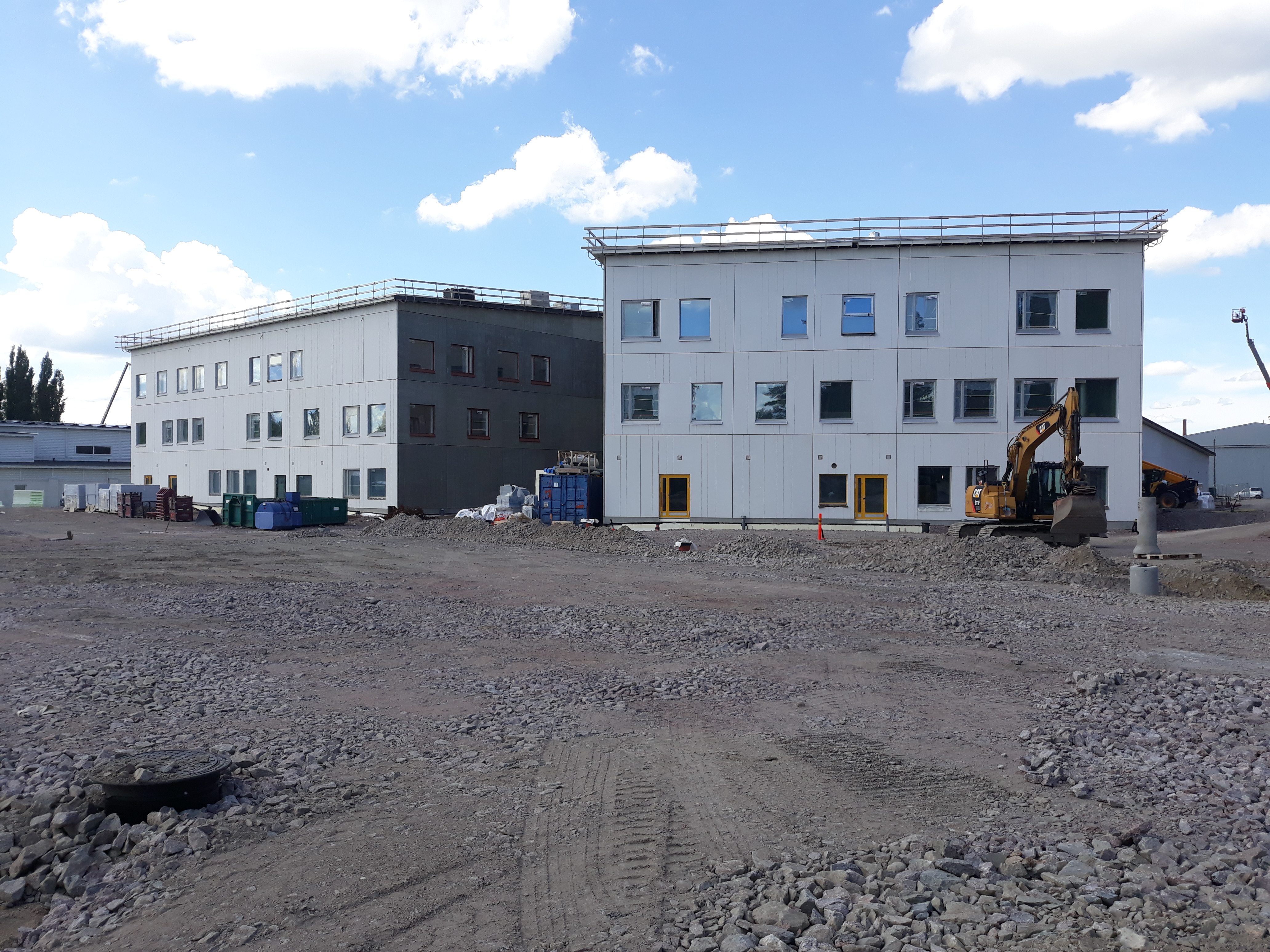 Kuvassa rakentuva koulukeskus jossa tulevat välituntipihat on tasoitettu ja näkyvissä tasoitettu sorastus ennen kuin muita pihan rakennekerroksia tulee.