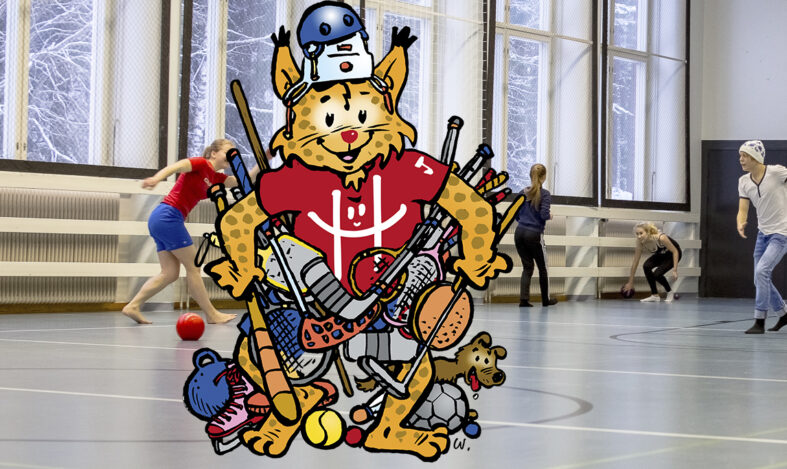 Kuntamaskotti-ilves harrastusvälineiden kanssa koulun salissa.