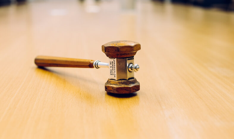 Puinen kokousnuija pöydällä.