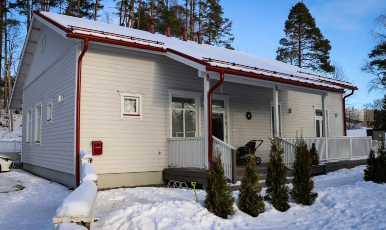 Valkoinen puutalo, päiväkoti talviauringossa.