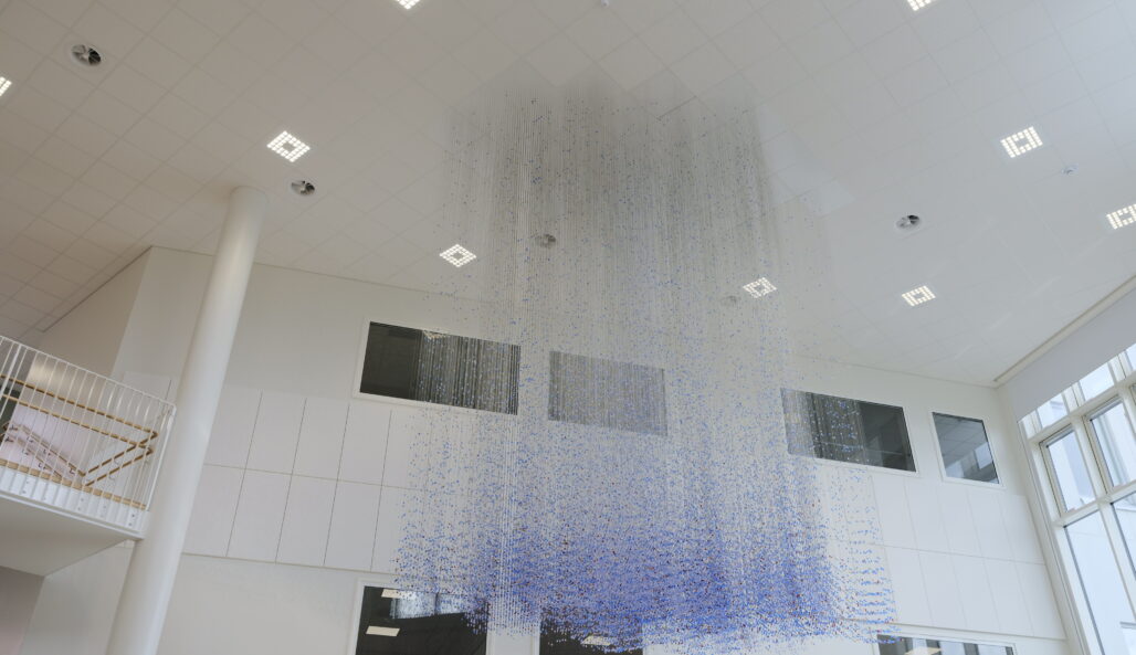 Lasihelmistä koostuva taideteos roikkuu katosta.