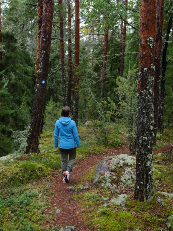 Nainen kävelee luontopolulla-