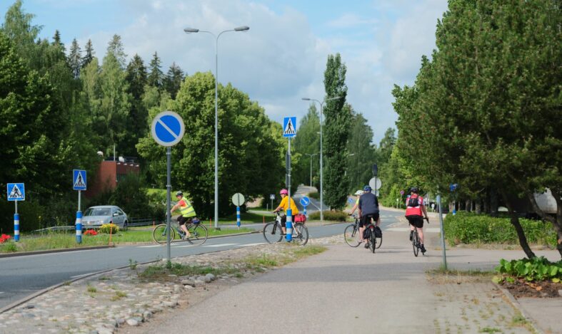 Pyöräilijöitä ylittämässä suojatietä.