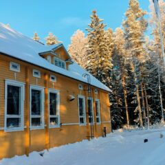 Jokimaan juhlatalon keltaiseksi maalattu julkisivu isoine ikkunoineen.