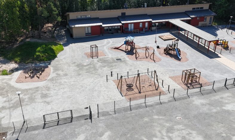 Porttilantien päiväkodin piha leikkivälineineen.