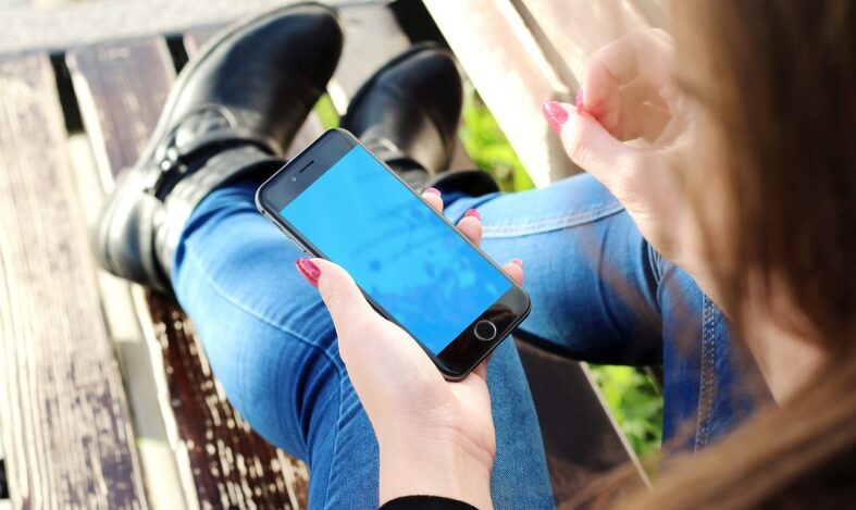 Naisella kädessä älypuhelin