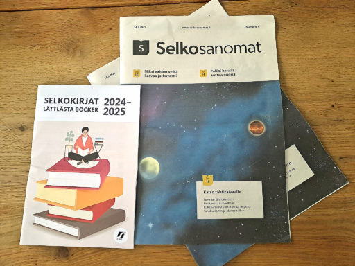 Sanomalehti Selkosanomat pöydällä. Lehden vieressä Selkokirjat-esite.