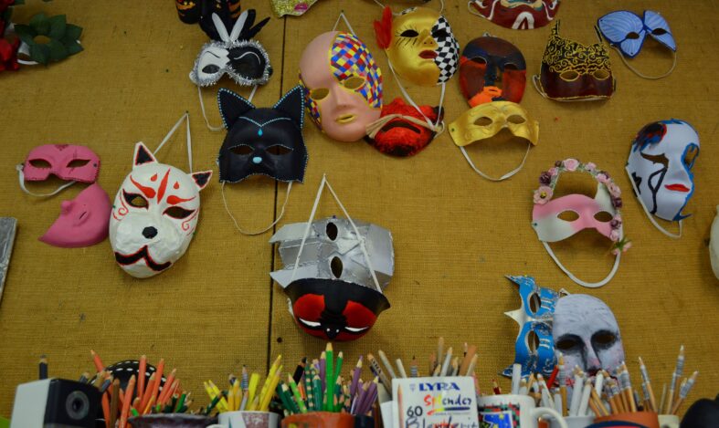 Oppilaiden tekemiä naamioita koulun ilmoitustaululla.