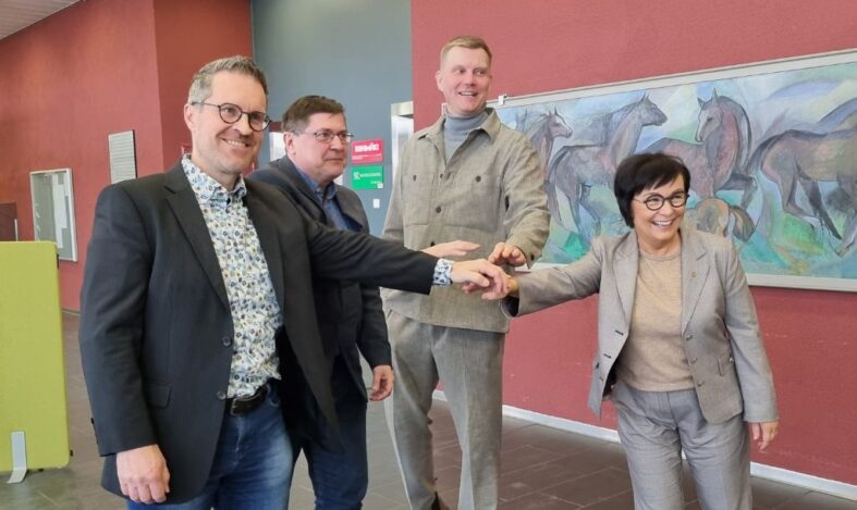 Neljä kunnanjohtajaa iloisina.