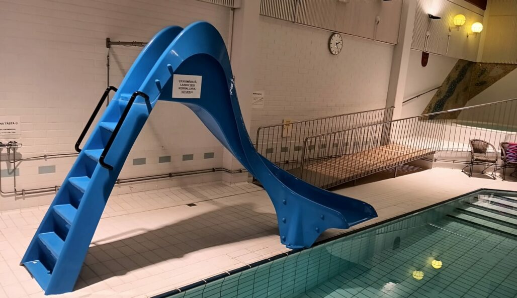 A blue water slide for children by a pool.