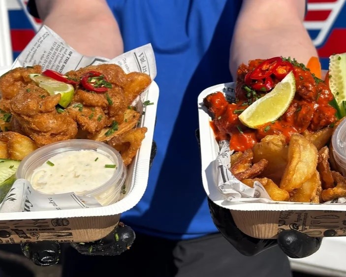 Kädet pitelemässä kehon edessä kahta kanansiipiannosta.